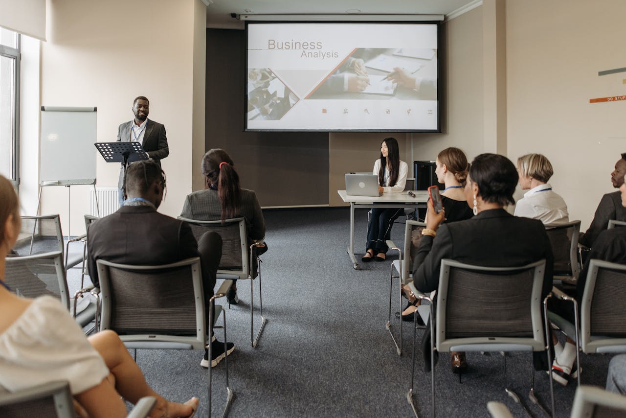 A diverse group of adults attending a presentation in a conference room setting.